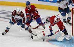 Andre Burakovsky (95) de l'Avalanche du Colorado tire la rondelle devant le gardien des Canadiens de Montréal Jake Allen tandis que Cole Caufield (22 ans) tente de créer une interférence lors de la troisième période à Montréal le jeudi 2 décembre 2021.
