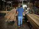 Un ouvrier empile du bois dans le Kentucky.  Dans le sud des États-Unis, où une grande quantité de bois d'œuvre d'Amérique du Nord est produite, les problèmes de main-d'œuvre affligent les scieries.