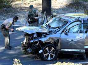 Les adjoints du shérif du comté de Los Angeles inspectent le véhicule du golfeur Tiger Woods, qui a été transporté d'urgence à l'hôpital après avoir subi de multiples blessures dans un accident impliquant un seul véhicule à Los Angeles, Californie, États-Unis, le 23 février 2021.