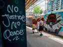 Des gens passent devant une peinture murale de George Floyd dans Graffiti Alley au centre-ville de Toronto, le 11 juin 2020. La célèbre ruelle de Toronto a été peinte de personnalités noires et de messages de solidarité contre le racisme anti-noir. 