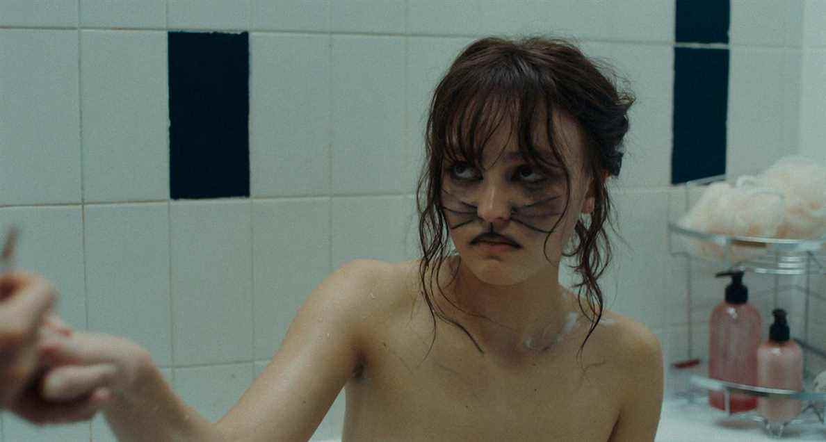 Lily Rose Depp, avec des moustaches de chat peintes sur son visage, a l'air méfiante hors écran dans Wolf