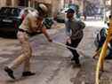 Un policier brandit sa matraque contre un homme en guise de punition pour avoir enfreint les règles de verrouillage après que l'Inde a ordonné un verrouillage national de 21 jours pour limiter la propagation de la maladie à coronavirus (COVID-19), à New Delhi, Inde, le 25 mars 2020.