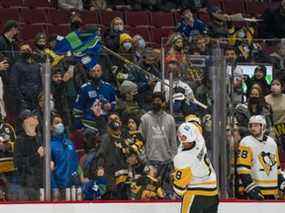 Le défenseur des Penguins de Pittsburgh Brian Dumoulin (8) ramasse un chandail de l'attaquant des Canucks de Vancouver Bo Horvat (53) qu'un partisan de Vancouver a jeté sur la glace vers la fin du temps réglementaire en troisième période au Rogers Arena.