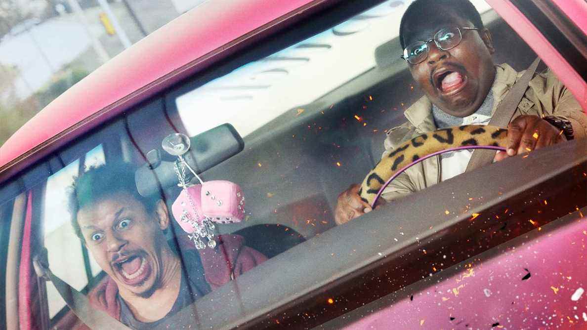 Eric Andre et Lil Rel Howery hurlant dans une voiture rose inclinée dans Bad Trip