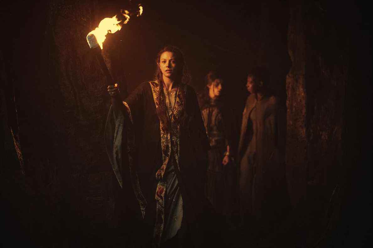 Deux elfes conduisent Yennefer de Vengerberg à travers une grotte aux flambeaux dans The Witcher de Netflix