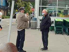 Ivan Scott (à gauche) de Gardez la GRC à Surrey et le maire de Surrey Doug McCallum s'engagent dans une conversation animée dans le stationnement d'une épicerie en septembre 2021.