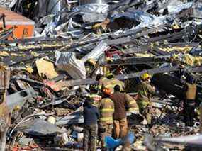 Les secouristes fouillent ce qui reste de l'usine de bougies de produits de consommation de Mayfield après sa destruction par une tornade à Mayfield, Kentucky, le 11 décembre 2021.