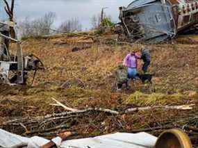 Des résidents locaux passent devant la scène d'un déraillement de train après qu'une épidémie dévastatrice de tornades a ravagé plusieurs États américains à Earlington, Kentucky, États-Unis, le 11 décembre 2021. REUTERS / Cheney Orr
