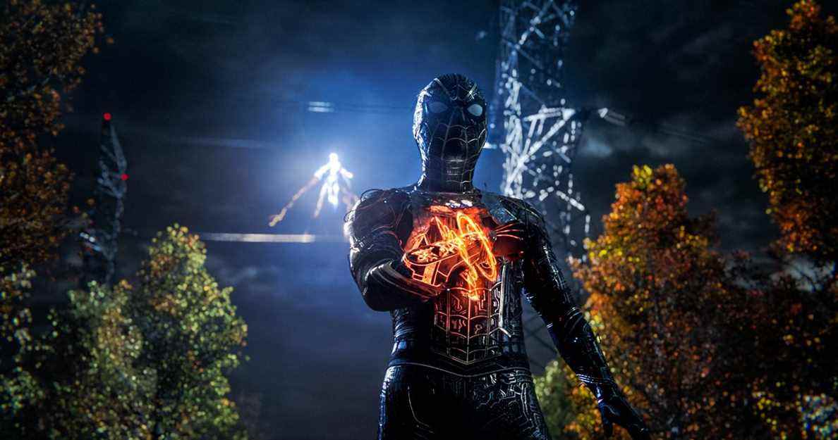 Spider-Man, vêtu d'un costume noir avec un appareil mystique au poignet, se tient dans une forêt sombre tandis qu'Electro apparaît en arrière-plan dans Spider-Man: No Way Home.