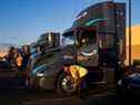 Les chauffeurs de camion Collette Hunt et Dan Andrews inspectent leurs camions avant leur quart de travail chez Amazon Freight Partner Seven Strong Trucking à Phoenix, Arizona.