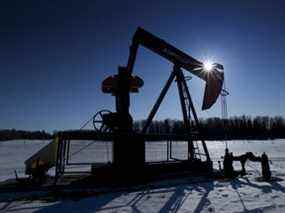 Un pumpjack pompe le pétrole d'un puits sur un champ gelé d'un agriculteur près de Pigeon Lake, en Alberta.