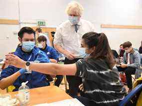 Le Premier ministre britannique Boris Johnson visite le centre de vaccination de Stow Health, à Westminster, Londres, le lundi 13 décembre 2021. Johnson dit que la Grande-Bretagne est confrontée à un « raz-de-marée » d'infections dues à la variante du coronavirus omicron et il a annoncé une énorme augmentation du rappel vaccins pour renforcer les défenses contre elle.