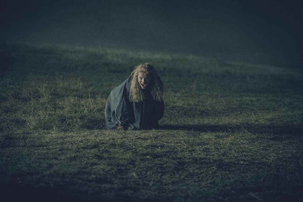 Une image fixe de Ciri dans The Witcher ;  elle est par terre en train de crier dans un champ