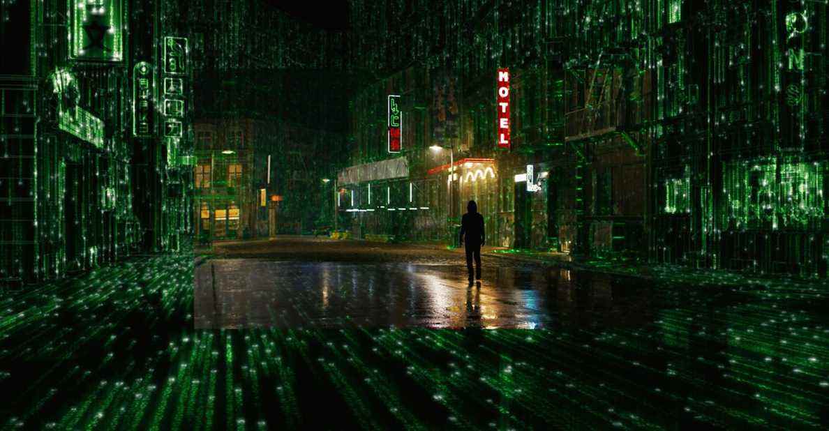 Thomas Anderson marche dans une rue de la ville alors qu'elle se transforme en code dans The Matrix Resurrections.