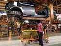 Un travailleur de l'automobile installe une batterie dans une Chevrolet Bolt dans une usine de General Motors à Detroit, Michigan.
