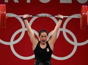 La Canadienne Maude Charron hurle alors qu'elle réussit à se soulever pour remporter une médaille d'or dans la compétition d'haltérophilie féminine de 64 kg le 27 juillet 2021.