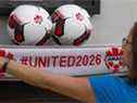 Un employé brandit un foulard avec le mot-clic pour la candidature nord-américaine à la Coupe du monde 2026 au siège social de Soccer Canada à Ottawa le 13 juin.