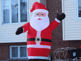 Un Père Noël gonflable se tient devant une maison à Cornwall, en Ontario.