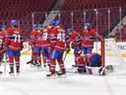 Des membres des Canadiens de Montréal se blottissent autour du gardien Cayden Primeau #30 alors qu'il s'allonge sur la glace avec inconfort après avoir effectué un arrêt pour aider à gagner le match en fusillade contre les Flyers de Philadelphie au Centre Bell le 16 décembre 2021 à Montréal.