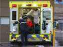 Des ambulanciers paramédicaux chargent une femme dans une ambulance à l'extérieur du service d'urgence de l'hôpital St. Mary's le 21 décembre 2021.
