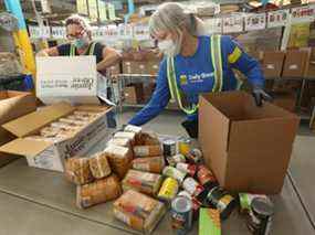 Les bénévoles de la Toronto Daily Bread Food Bank emballent les marchandises dans des boîtes destinées aux nécessiteux le mois dernier.  Les responsables du DBFB ont déclaré que la demande avait augmenté de 30% cette année.