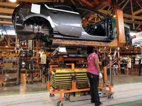 Un travailleur de l'automobile installe une batterie dans une Chevrolet Bolt dans une usine de General Motors à Detroit, Michigan.