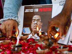 Des gens allument des lampes à huile à côté de roses pour exprimer leurs condoléances au peuple du Sri Lanka, à la suite du lynchage du directeur sri-lankais d'une usine de confection après une attaque contre l'usine de Sialkot, à Karachi, au Pakistan, le 5 décembre 2021.