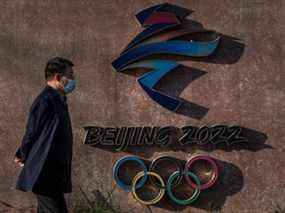 Un visiteur passe devant le logo des Jeux olympiques d'hiver de Pékin 2022 à Shougang, une ancienne centrale électrique qui abrite désormais également le siège du comité d'organisation des Jeux olympiques de Pékin, le 7 décembre 2021 à Pékin, en Chine.