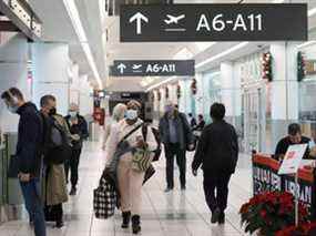 Les passagers à destination des États-Unis marchent dans le terminal 3 de l'aéroport Pearson de Toronto, quelques jours avant l'entrée en vigueur des nouveaux protocoles de test COVID-19 pour entrer aux États-Unis, à Toronto, le 3 décembre 2021.