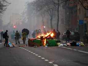 Des objets en feu sont vus dans la rue lors d'une manifestation contre les restrictions imposées par le gouvernement belge pour contenir la propagation du COVID-19, à Bruxelles, le 5 décembre 2021.