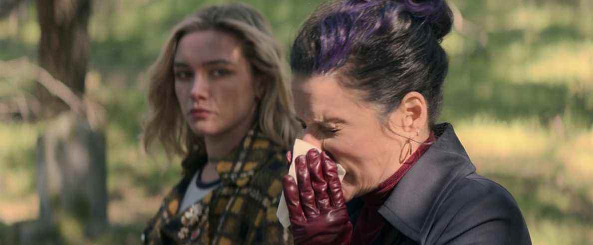 Valentina Allegra de Fontaine (Julia Louis-Dreyfus) se mouche sur la tombe de Black Widow sous le regard de Yelena Belova (Florence Pugh), agacée dans Black Widow.