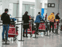 Les voyageurs internationaux attendent le transport vers un hôtel de quarantaine COVID-19 après leur arrivée à l'aéroport international Pearson, le 24 février 2021.