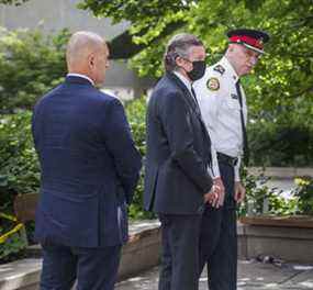Le chef de la police de Toronto, James Ramer, accompagné du président de l'Association des policiers de Toronto, Jon Reid (à gauche) et du maire John Tory, devant l'hôtel de ville de Toronto, le 2 juillet 2021.