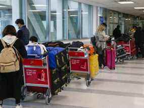 Les passagers de l'aéroport Pearson de Toronto attendent de se diriger vers les hôtels pour se mettre en quarantaine le lundi 1er mars 2021.