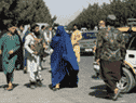 Les forces talibanes bloquent les routes autour de l'aéroport de Kaboul, alors qu'une femme passe, le 27 août 2021. Après que le Canada a annoncé son dernier vol hors d'Afghanistan, de nombreux cuisiniers, gardes et traducteurs qui avaient aidé les Canadiens se sont retrouvés bloqués.