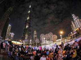 Cette photo prise avec un objectif fisheye montre des personnes attendant le feu d'artifice du Nouvel An sous Burj Khalifa à Dubaï le 31 décembre 2021.