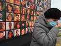 Une femme pleure devant un écran géant portant des portraits de défunts membres d'équipage et passagers du vol 752 d'Ukraine International Airlines, qui s'est écrasé en Iran un an auparavant, lors d'une cérémonie commémorative le 8 janvier 2021 sur le site d'un futur mémorial sur le Rive du fleuve Dnipro dans la capitale ukrainienne Kiev.  