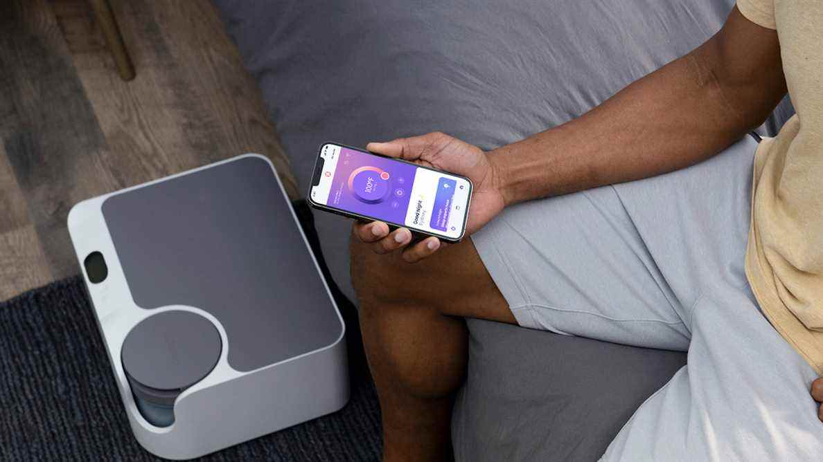 Une personne utilise l'application Sleepme+ avec le système de sommeil Sleepme Dock Pro pour contrôler la température de son lit