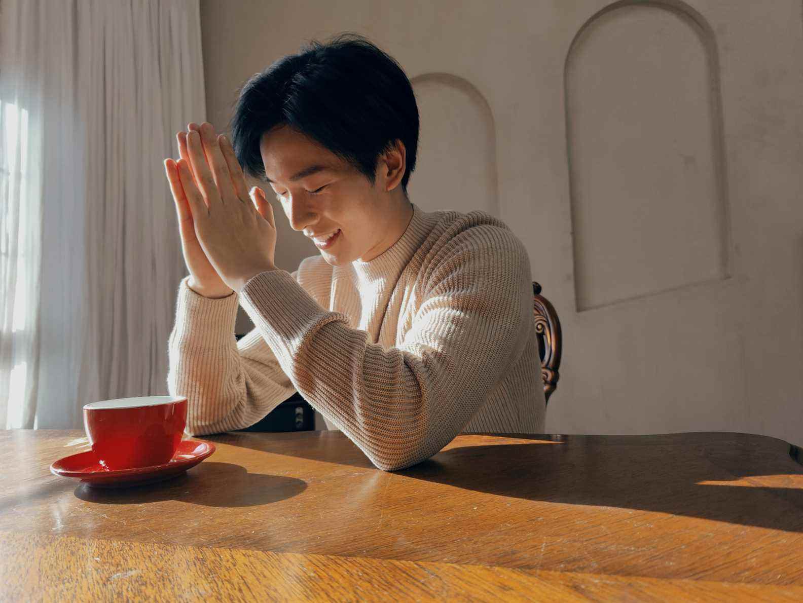 Un exemple d'image OnePlus 10 Pro d'une personne assise à une table avec une tasse de café