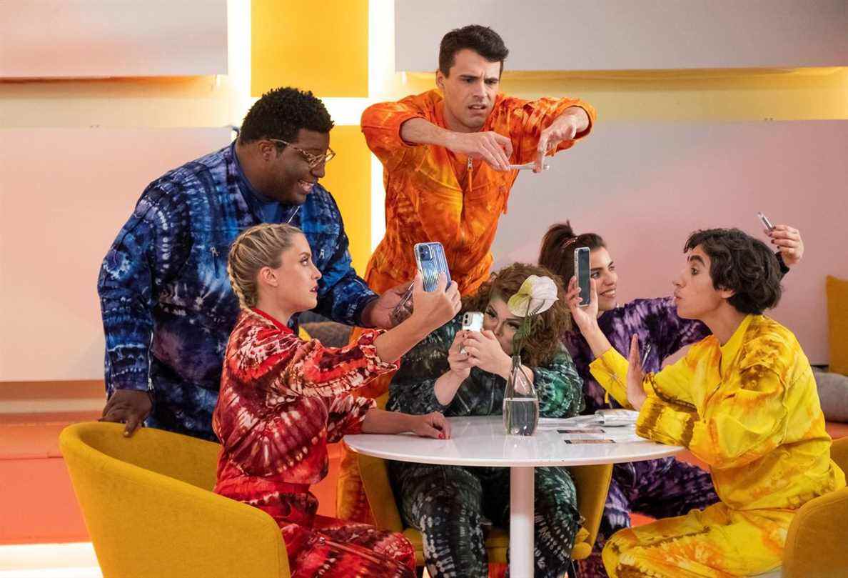 Les influenceurs du culte de Dory sont assis autour d'une table dans des combinaisons aux couleurs vives dans la saison 5 de Search Party
