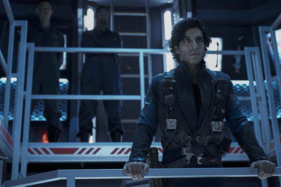 Keon Alexander (Marco Inaros) se tient devant une balustrade dans une pièce bleue dans The Expanse