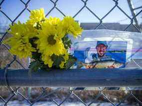 Des fleurs et une photo d'un homme ont été placées sur une clôture à l'extérieur de l'entrée d'Eastway Tank Pump & Meter Ltd. samedi.  Les investigations se poursuivaient sur le site de l'entreprise constructeur de camions-citernes deux jours après une explosion et un incendie mortels.