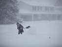 La neige abondante rend le pelletage particulièrement difficile pour Andra Morrison dans un quartier de Nepean près d'Ottawa.