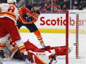 L'attaquant des Oilers d'Edmonton Leon Draisaitl marque un but contre le gardien des Flames de Calgary Jacob Markstrom au Rogers Place d'Edmonton le samedi 22 janvier 2022.