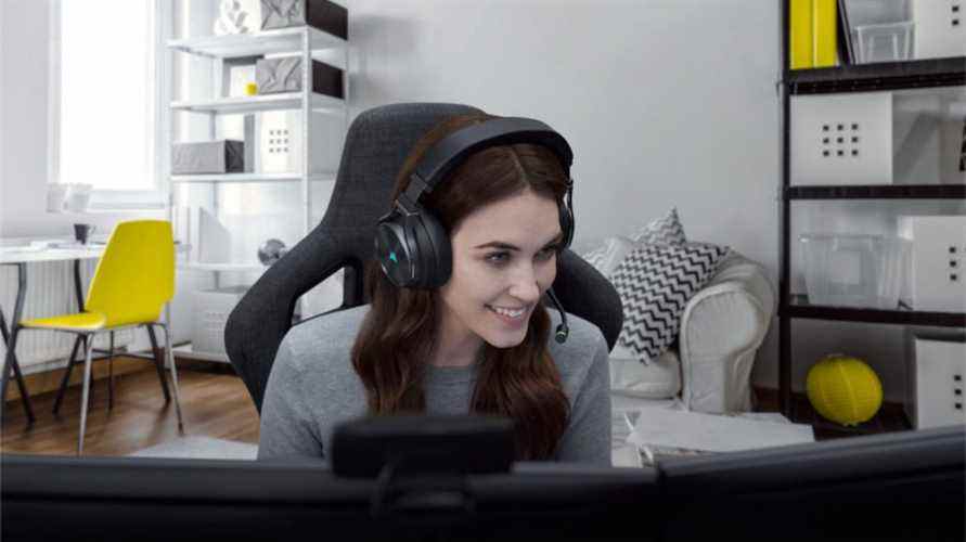 Une femme joue sur son PC de jeu à l'aide du casque de jeu Corsair Virtuoso RGB Wireless XT