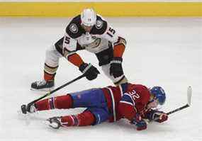 Ryan Getzlaf (15 ans) des Ducks d'Anaheim fait tomber Rem Pitlick (32 ans) des Canadiens de Montréal lors de la première période à Montréal le jeudi 27 janvier 2022.