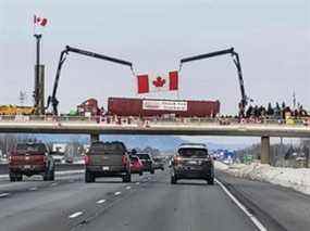 Des Canadiens bordent un pont dans la région de Niagara pour montrer leur soutien au Freedom Convoy de camionneurs se dirigeant vers Ottawa depuis divers points à travers le pays pour protester contre les mandats et les restrictions du vaccin COVID.
