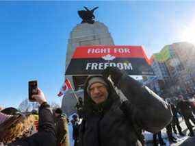 Un homme non identifié pose pour une photo devant le Monument commémoratif de guerre du Canada samedi.