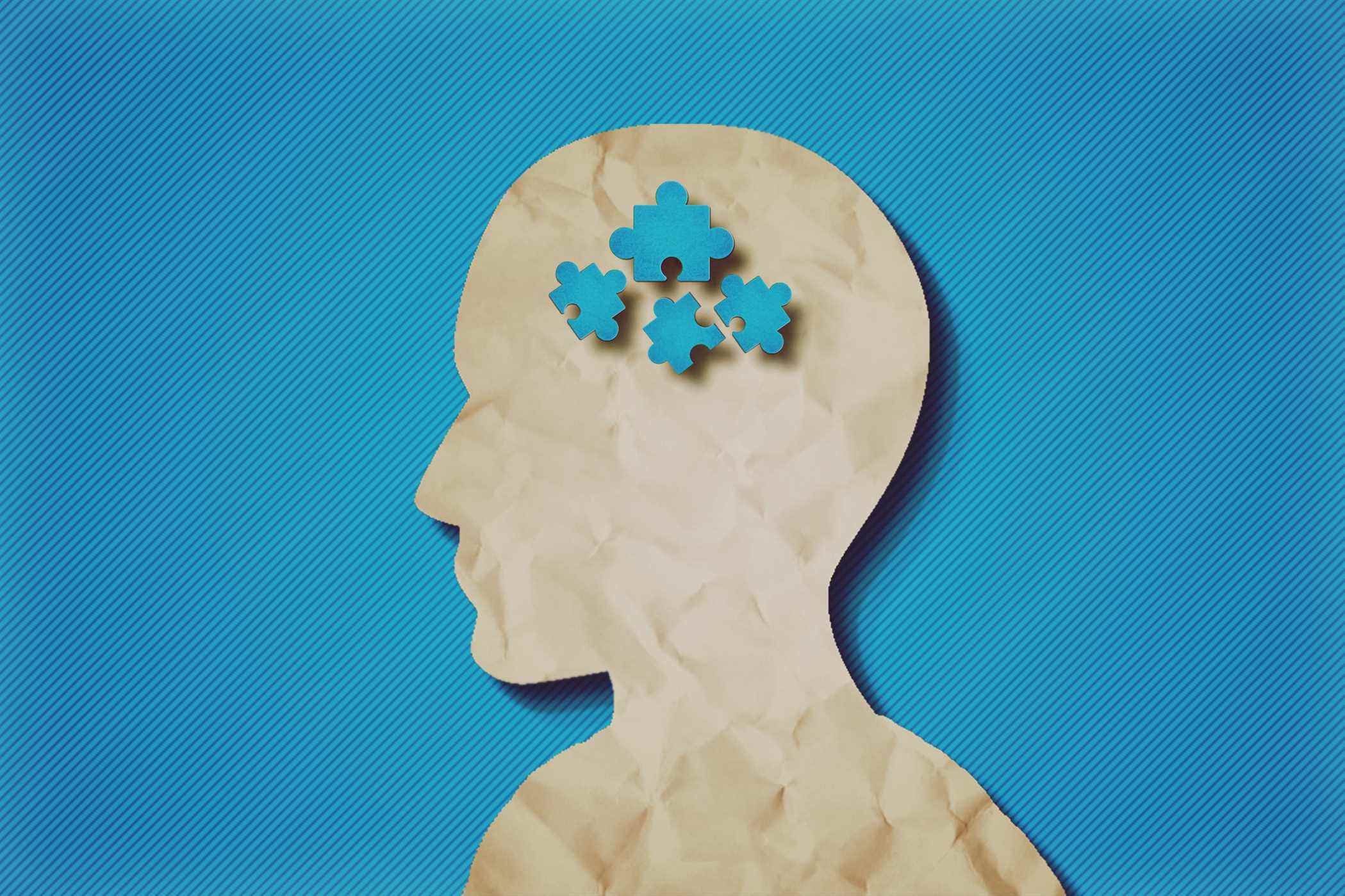 tête de papier avec des pièces de puzzle-concept d'autisme.fond bleu