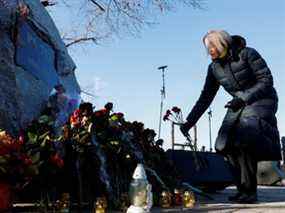 Une femme dépose des fleurs lors d'une cérémonie marquant le deuxième anniversaire de l'écrasement du vol PS752 d'Ukraine International Airlines dans l'espace aérien iranien, à Kiev, en Ukraine, le 8 janvier 2022.